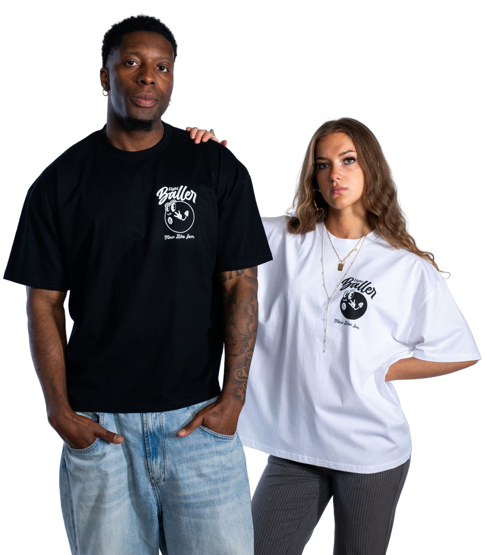 Urban fashion models wearing monochrome Eight Baller streetwear t-shirts from a UK clothing brand. Male model in black tee and light-wash jeans, female model in oversized white tee and ribbed trousers. Front chest logos feature stylized 8-ball graphic and 'Flow Like Zen' text. Minimalist unisex street style look.