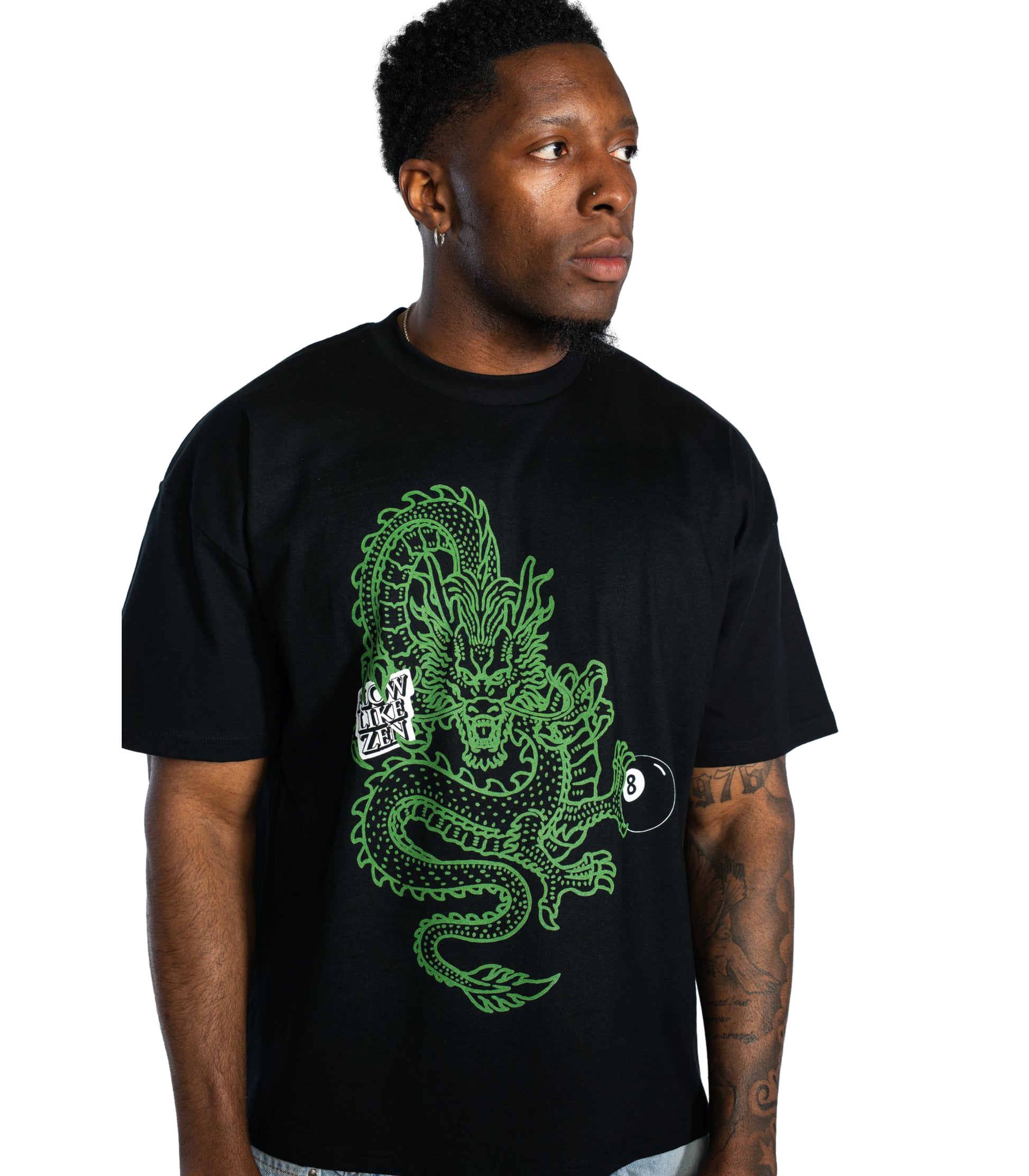 Close-up of male model wearing Flow Like Zen black Dragon’s Grip graphic t-shirt featuring green dragon and 8-ball design; bold British streetwear style from independent UK fashion brand.