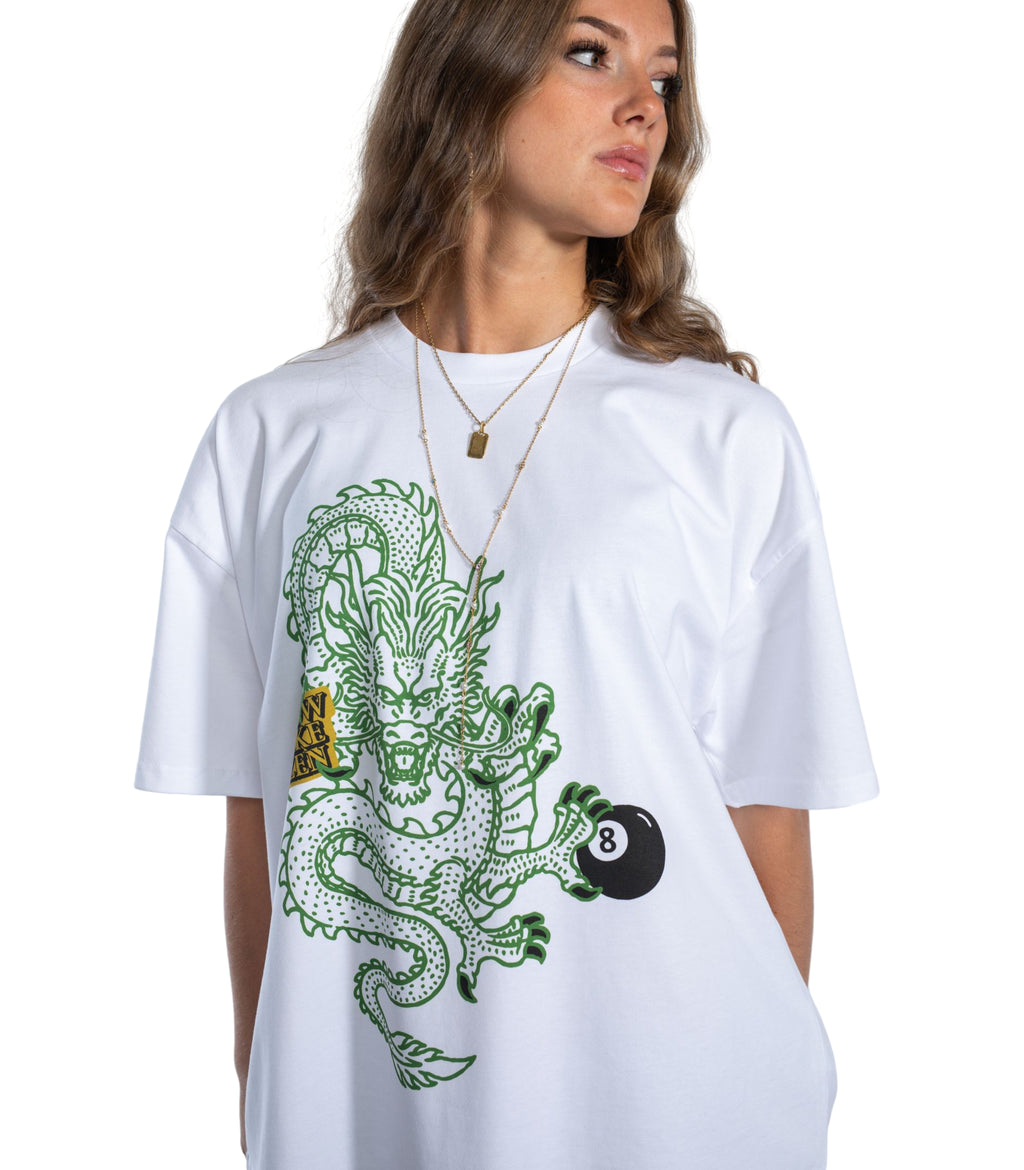 Female model wearing Flow Like Zen Dragon’s Grip white oversized graphic t-shirt featuring green dragon and 8-ball artwork; premium British streetwear with unisex urban style, made in the UK.